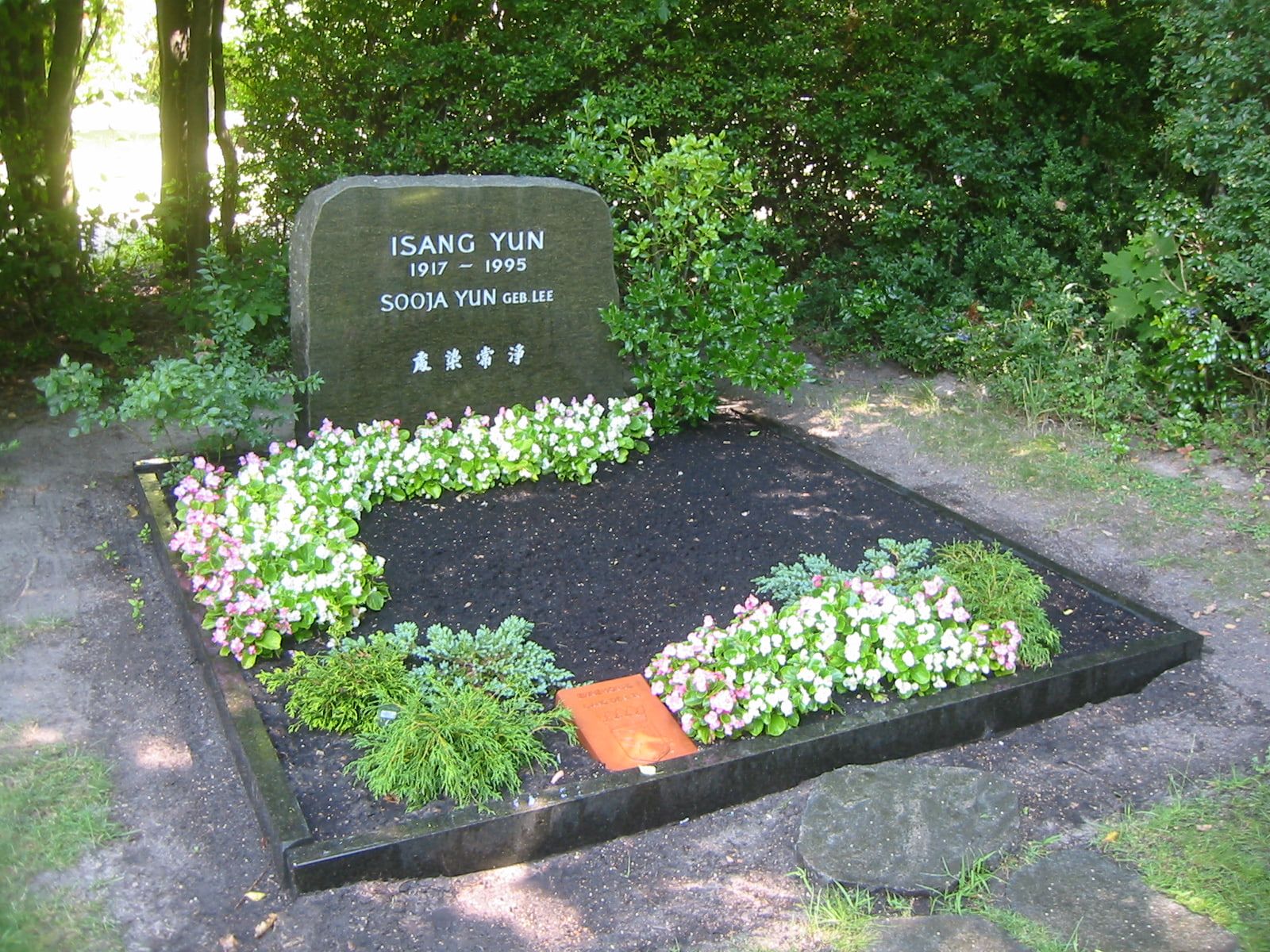 Historic view of the planted memorial bearing the names Isang Yun and Sooja Yun; Isang Yun was reinterred in South Korea in 2018 at Gatow Landscape Cemetery